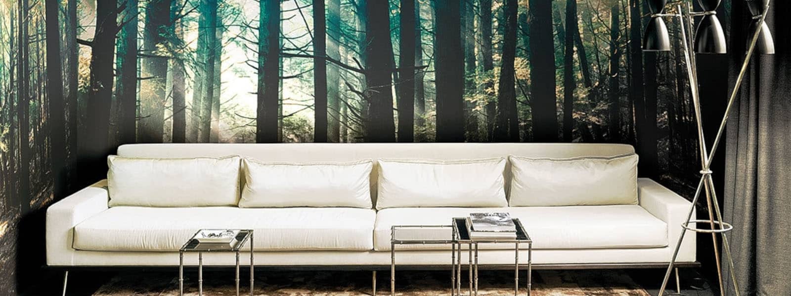 Weißes Sofa im Vordergrund und Waldtapete von Londonart im Hintergrund